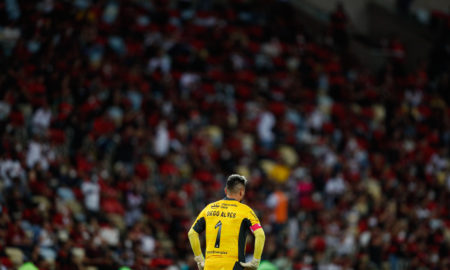 Diego Alves e a torcida do Flamengo desfocada ao fundo no estádio