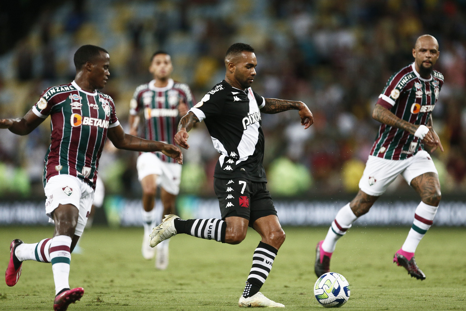 Alex Teixeira conduz a bola enquanto jogador do Fluminense se aproxima