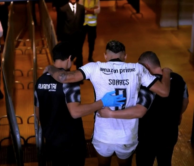 Tiquinho Soares saindo com auxilio após sofrer uma entorse no joelho esquerdo.(Reprodução/SporTV/Premiere.)