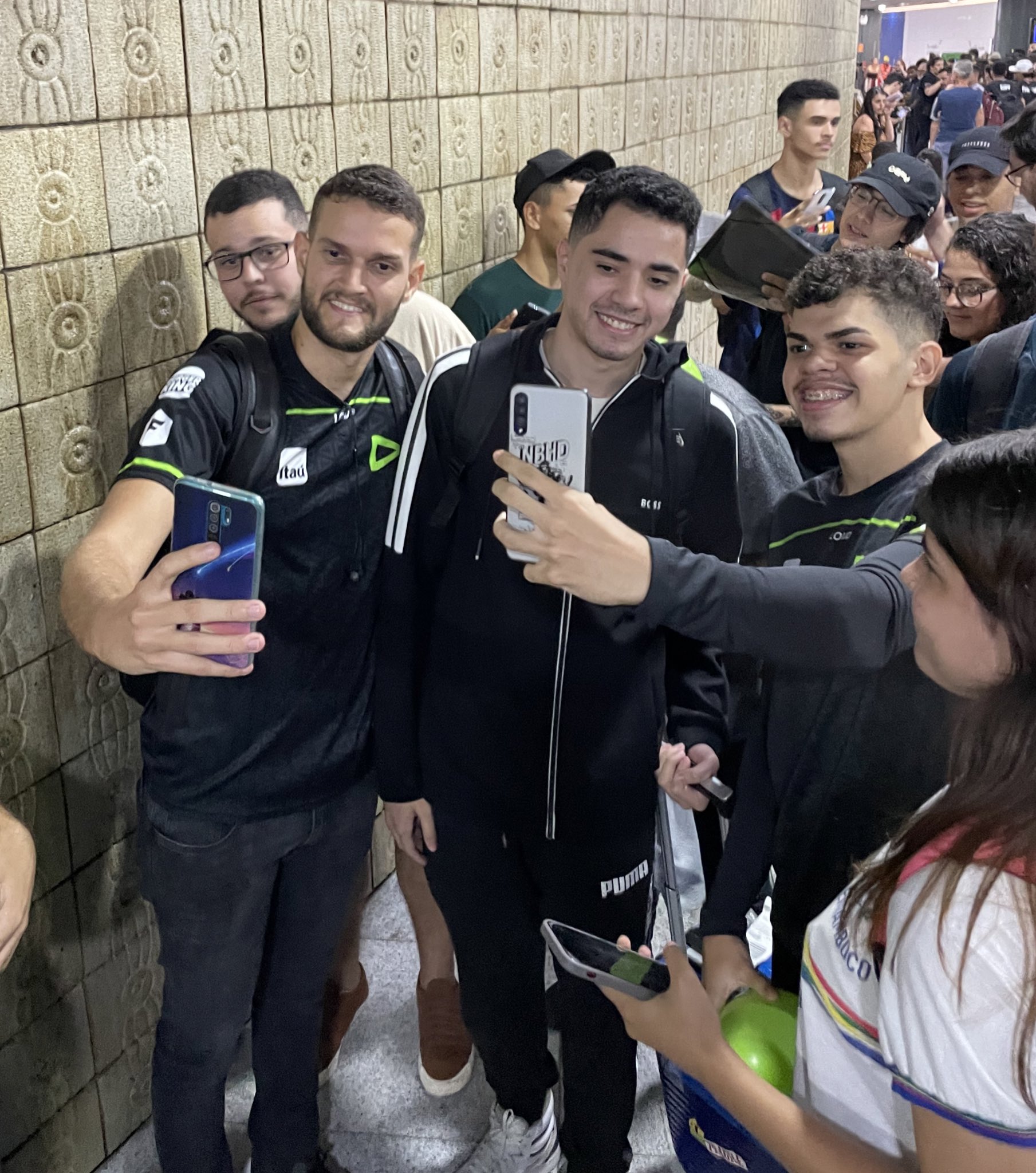 Ceos (centro), jogador da LOUD, tira foto com torcedores no aeroporto em Recife — Foto: Divulgação/CBLOL