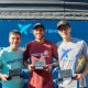 Rafael Moura, de vermelho, ao centro com o troféu do Beach Tennis com Pablo Oliveira à direita, de cinza. À esquerda, Ricardo Aloise / Crédito: Diogo Keng