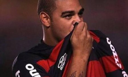 Adriano Imperador beijando a o escudo na camisa do Flamengo.