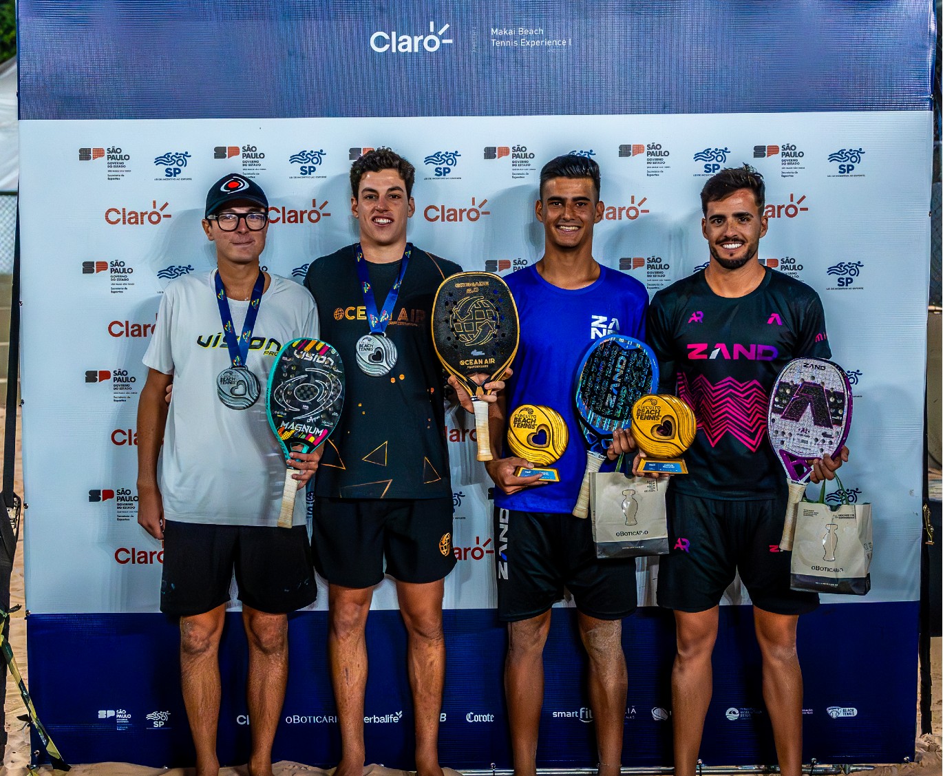 Foto: Antomi Ramos de preto e rosa e Mola de azul com o troféu (Foto: @workaholicris)